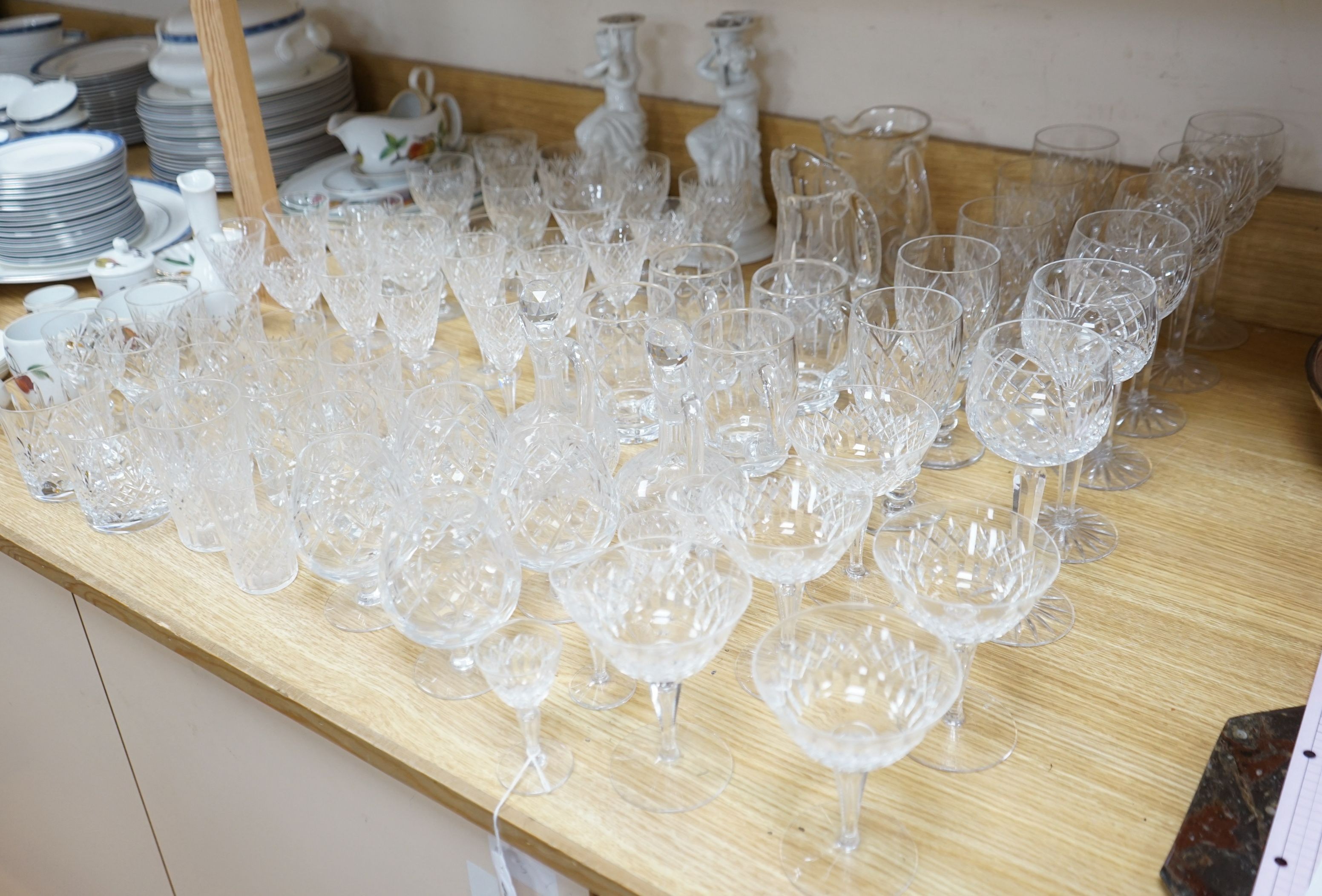 A suite of cut drinking glassware and a pair of porcelain figural lamp stems